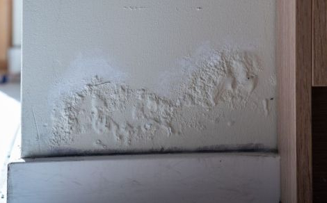 Optrekkend vocht op de muur vlak boven de plint