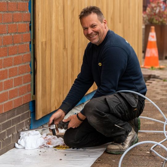 Een vochtspecialist van Murprotec injecteert de muur 