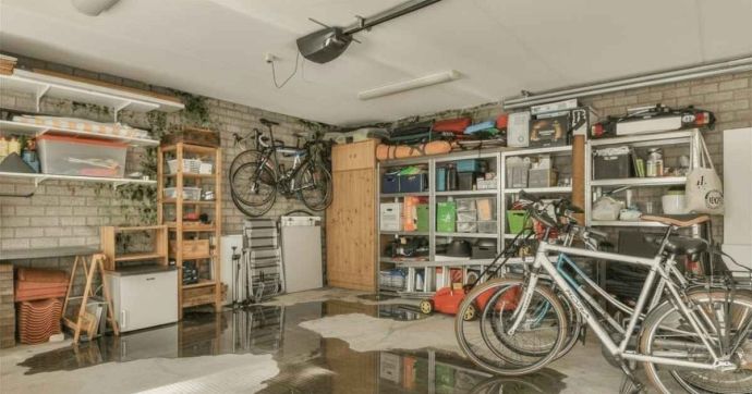 Garage met schimmel op de muren en water op de garagevloer