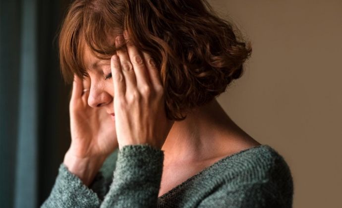 vrouw zit met de handen in het haar 