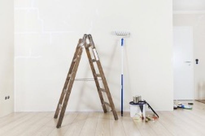 Ladder en verfborstel tegen de muur