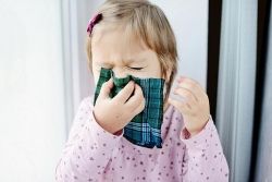 Een meisje snuit haar neus in een groene zakdoek